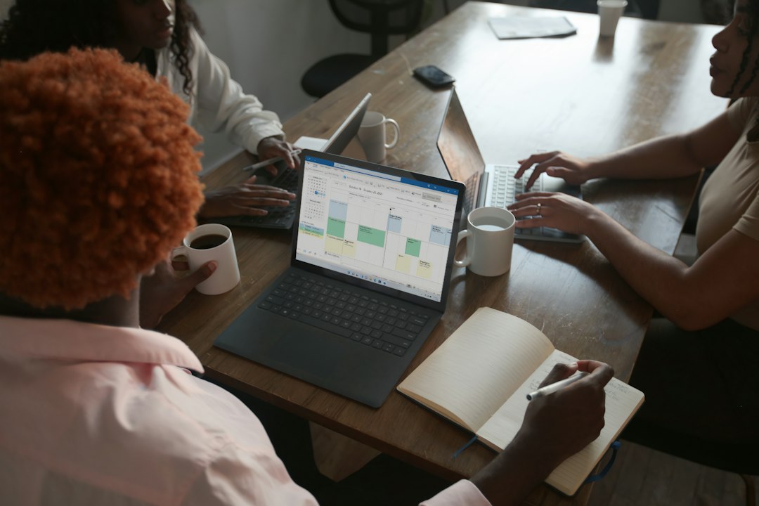 Small business team collaborating around a Microsoft laptop